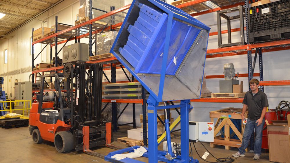 Customer side loaded box dumper with hold down bar
