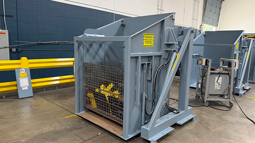 Box dumper with powered hold down bar